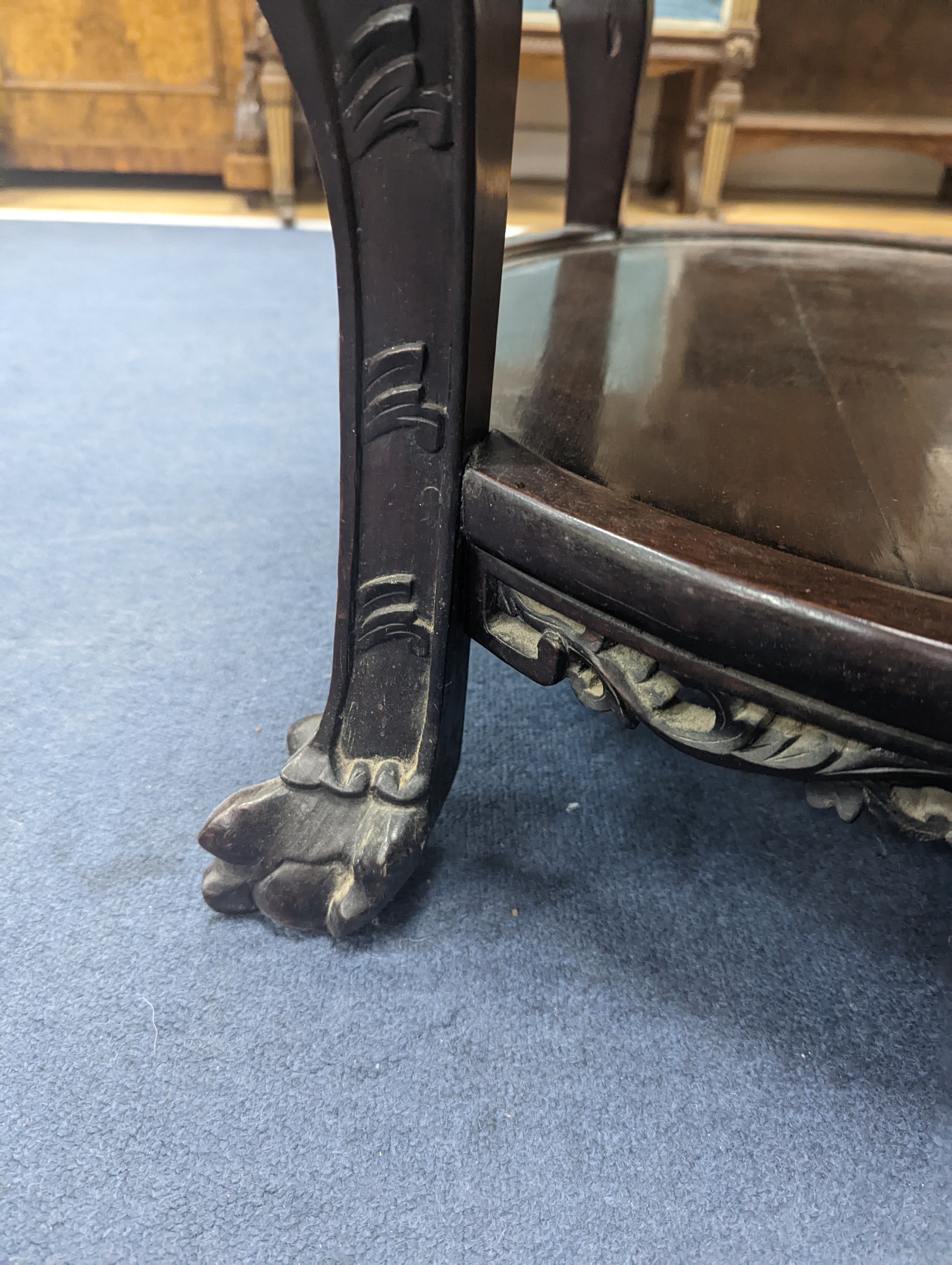 An early 20th century Chinese carved hardwood two tier table, diameter 64cm, height 56cm